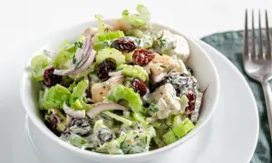 Salade de poulet crémeuse avec des morceaux de branche de céleri croquants, des canneberges séchées et des oignons rouges.
