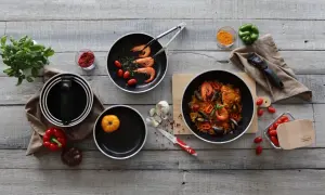 Préparation d'une paella savoureuse dans une poêle au meilleur revêtement. Ingrédients frais et ustensiles de cuisine de qualité.