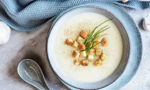 Délicieuse soupe de mache crémeuse, garnie de croûtons dorés et de ciboulette fraîche. Une touche de poivre pour parfaire ce plat réconfortant.