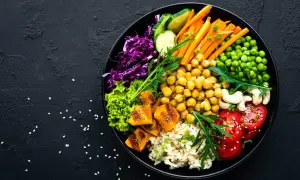 Un bol coloré avec riz, pois chiches, carottes, tomates, courge, chou rouge, laitue et pois. Un plat sain et savoureux, plein de legume en f.