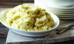 Un plat de purée celeri pomme de terre crémeuse, garnie de fines herbes, prête à être dégustée.