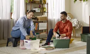 Couple rangeant des objets dans des boîtes, une étape pour vider sa maison pour alléger sa vie.