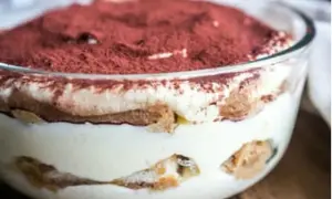 Un délicieux tiramisu maison, prêt à être dégusté. Une couche de crème onctueuse, des biscuits imbibés et une généreuse saupoudrée de cacao.