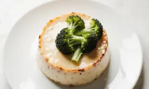 Un flan de brocolis, crémeux et doré, est garni de quelques fleurettes de brocolis frais.