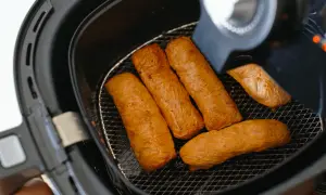 Cinq saucisses dorées dans une friteuse sans huile. Découvrez comment ça marche pour des repas sains et croustillants !