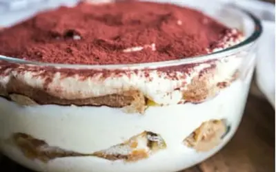 Un délicieux tiramisu maison, prêt à être dégusté. Une couche de crème onctueuse, des biscuits imbibés et une généreuse saupoudrée de cacao.