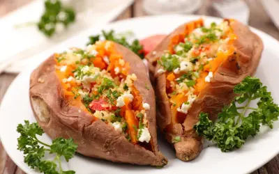 Deux patates douces rôties, garnies de couscous, feta et persil. Une recette simple et savoureuse pour la cuisson patate douce.