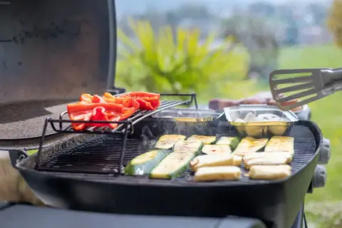 Poivrons rouges et courgettes grillés sur un barbecue à gaz. Le temps de cuisson barbecue gaz est idéal pour ces légumes savoureux.