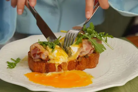 Un délicieux pain perdu salé avec œuf poché coulant, bacon croustillant et roquette fraîche.