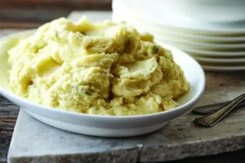 Un plat de purée celeri pomme de terre crémeuse, garnie de fines herbes, prête à être dégustée.