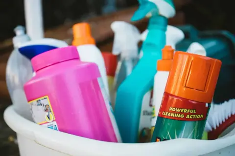 Un assortiment de produits de nettoyage, dont un spray bleu vif et une bouteille rose, prêts pour un nettoyage puissant. Ce produit fait maison est efficace.