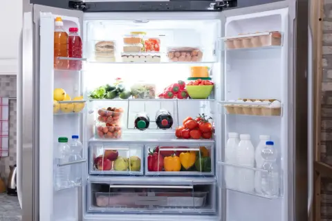 Un frigo bien rangé : fruits, légumes, œufs, bouteilles et boîtes de conserve organisés. 10 astuces pour un frigo impeccable.