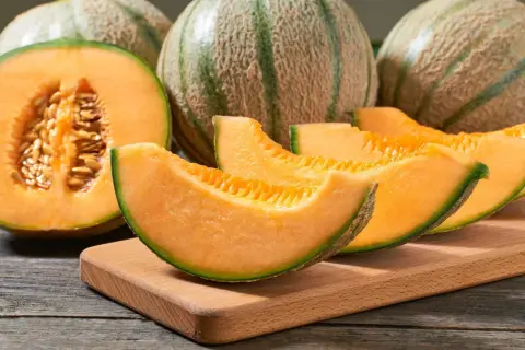 Des melons cantaloups coupés en quartiers, révélant leur chair orangée et leurs pépins. Un délice pour reconnaître un melon mur.