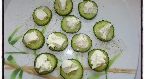 Apéro concombre st môret : rondelles de concombre garnies de fromage frais, saupoudrées de poivre. Parfait pour un apéritif léger et frais.