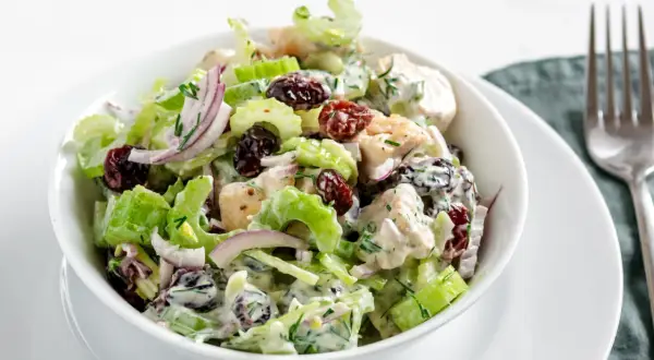 Salade de poulet crémeuse avec des morceaux de branche de céleri croquants, des canneberges séchées et des oignons rouges.