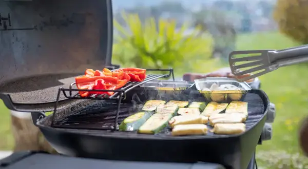 Poivrons rouges et courgettes grillés sur un barbecue à gaz. Le temps de cuisson barbecue gaz est idéal pour ces légumes savoureux.