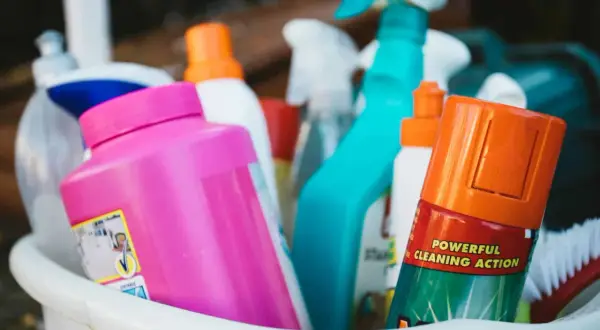 Un assortiment de produits de nettoyage, dont un spray bleu vif et une bouteille rose, prêts pour un nettoyage puissant. Ce produit fait maison est efficace.