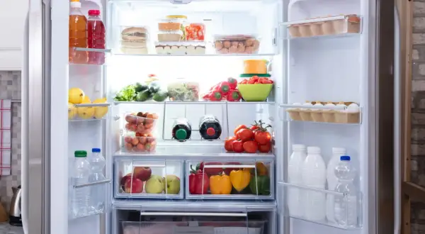 Un frigo bien rangé : fruits, légumes, œufs, bouteilles et boîtes de conserve organisés. 10 astuces pour un frigo impeccable.