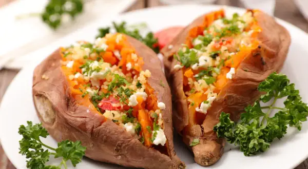 Deux patates douces rôties, garnies de couscous, feta et persil. Une recette simple et savoureuse pour la cuisson patate douce.