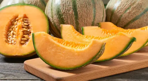 Des melons cantaloups coupés en quartiers, révélant leur chair orangée et leurs pépins. Un délice pour reconnaître un melon mur.