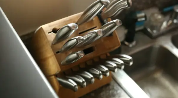 Un bloc en bois bien rangé pour une collection de couteaux de cuisine, montrant des lames en acier inoxydable prêtes à l'emploi.