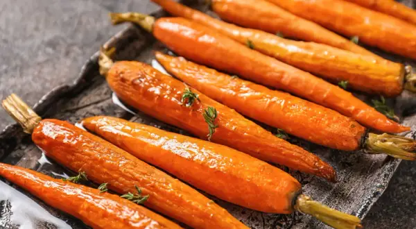 Carottes rôties glacées, garnies de thym frais. Une recette carotte originale qui met en valeur leur douceur naturelle.