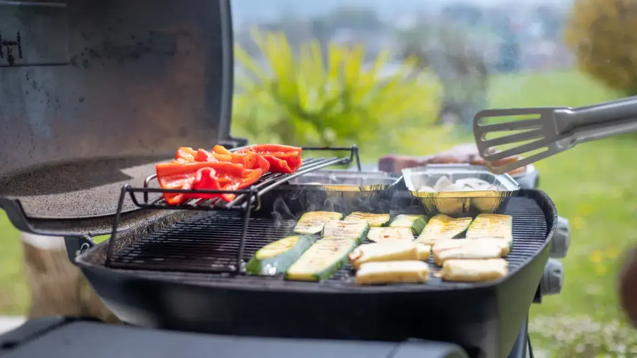 Poivrons rouges et courgettes grillés sur un barbecue à gaz. Le temps de cuisson barbecue gaz est idéal pour ces légumes savoureux.