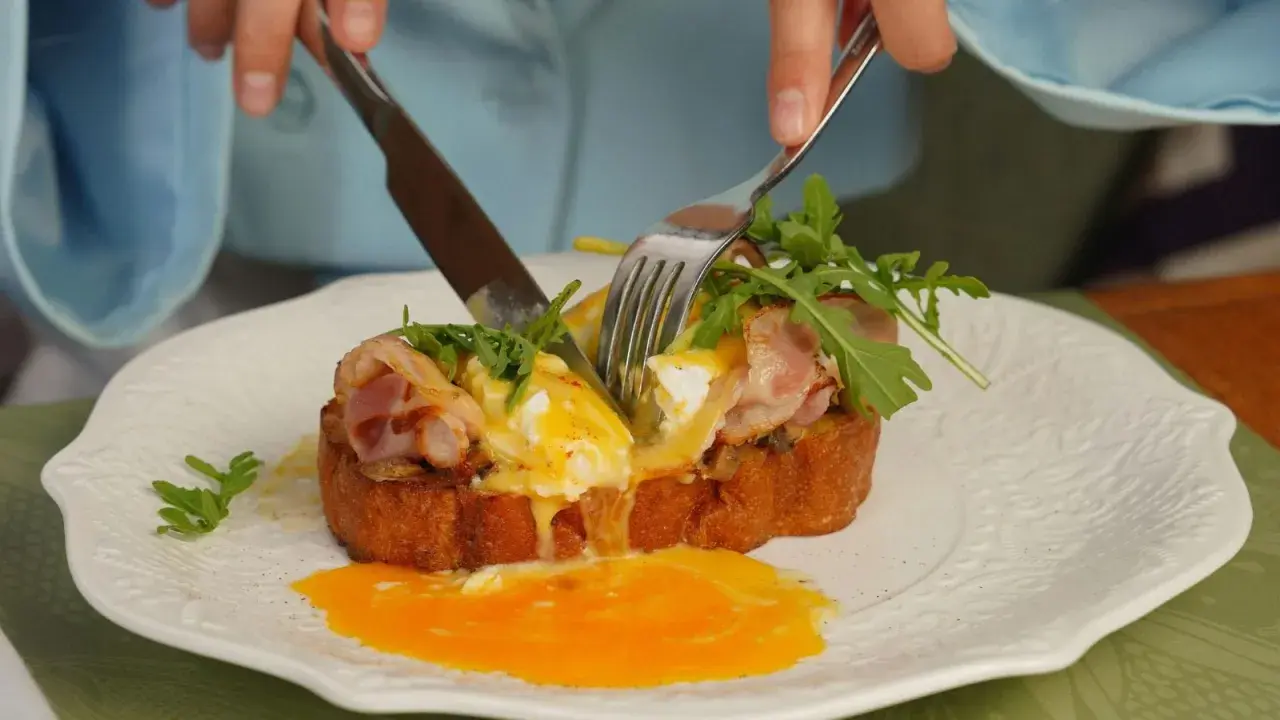 Un délicieux pain perdu salé avec œuf poché coulant, bacon croustillant et roquette fraîche.
