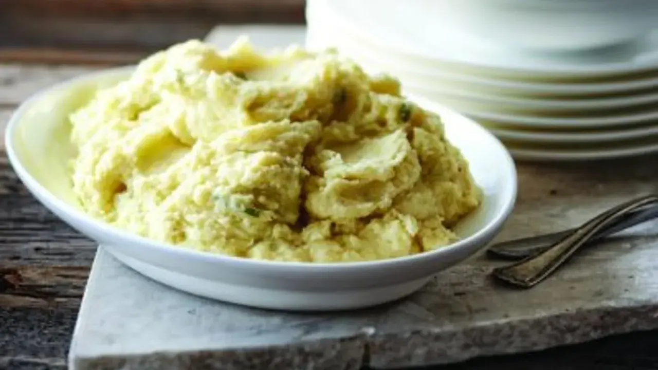 Un plat de purée celeri pomme de terre crémeuse, garnie de fines herbes, prête à être dégustée.