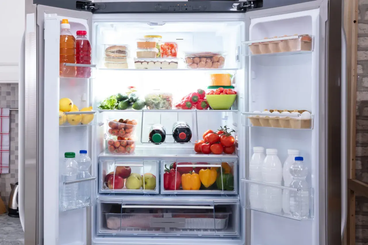 Un frigo bien rangé : fruits, légumes, œufs, bouteilles et boîtes de conserve organisés. 10 astuces pour un frigo impeccable.