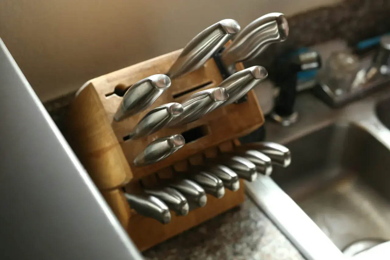Un bloc en bois bien rangé pour une collection de couteaux de cuisine, montrant des lames en acier inoxydable prêtes à l'emploi.