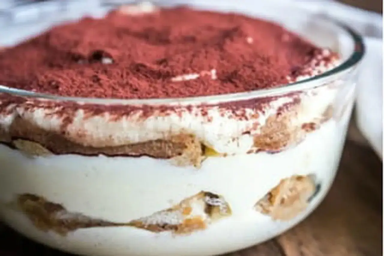 Un délicieux tiramisu maison, prêt à être dégusté. Une couche de crème onctueuse, des biscuits imbibés et une généreuse saupoudrée de cacao.