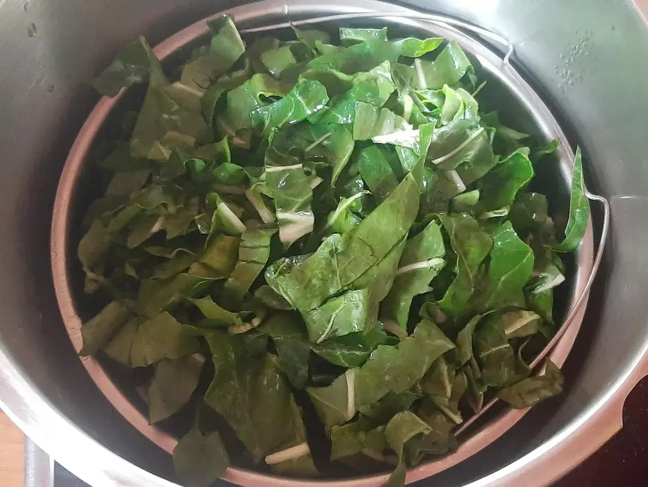 Feuilles de blette coupées en morceaux, prêtes à être cuisinées. Elles sont d'un vert vif et semblent fraîches.