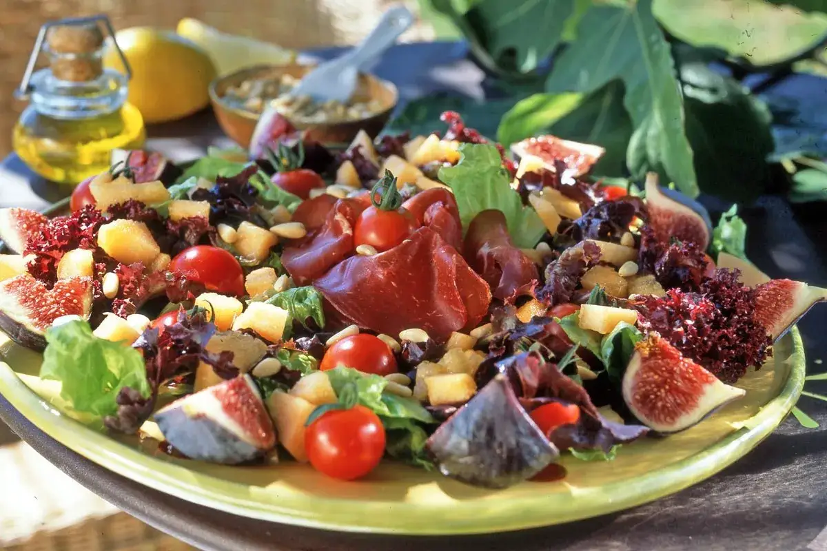 Salade color&eacute;e avec figues, tomates cerises, charcuterie, et quelques pignons de pin croquants.