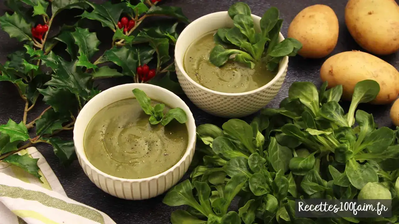 Deux bols de soupe de m&acirc;che, garnie de feuilles fra&icirc;ches, avec des pommes de terre et du houx en arri&egrave;re-plan.