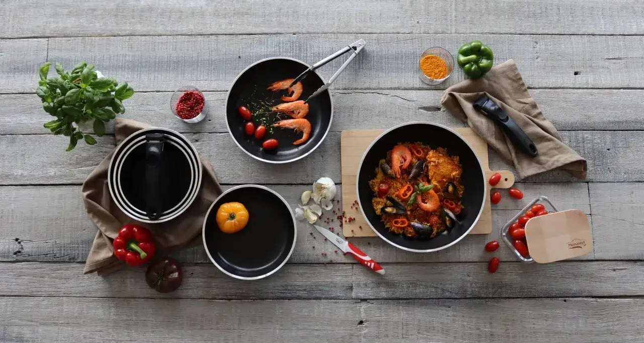 Pr&eacute;paration d'une paella savoureuse dans une po&ecirc;le au meilleur rev&ecirc;tement. Ingr&eacute;dients frais et herbes aromatiques sur fond de bois.