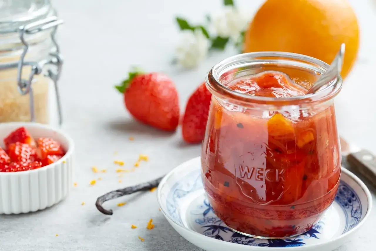 Un pot de confiture de framboise grand-m&egrave;re, aux fraises et &agrave; l'orange, avec une gousse de vanille.