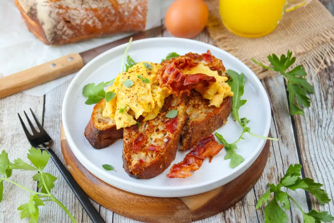 Un d&eacute;licieux pain perdu sal&eacute; garni d'&oelig;ufs brouill&eacute;s et de bacon croustillant, pr&ecirc;t &agrave; &ecirc;tre d&eacute;gust&eacute;.