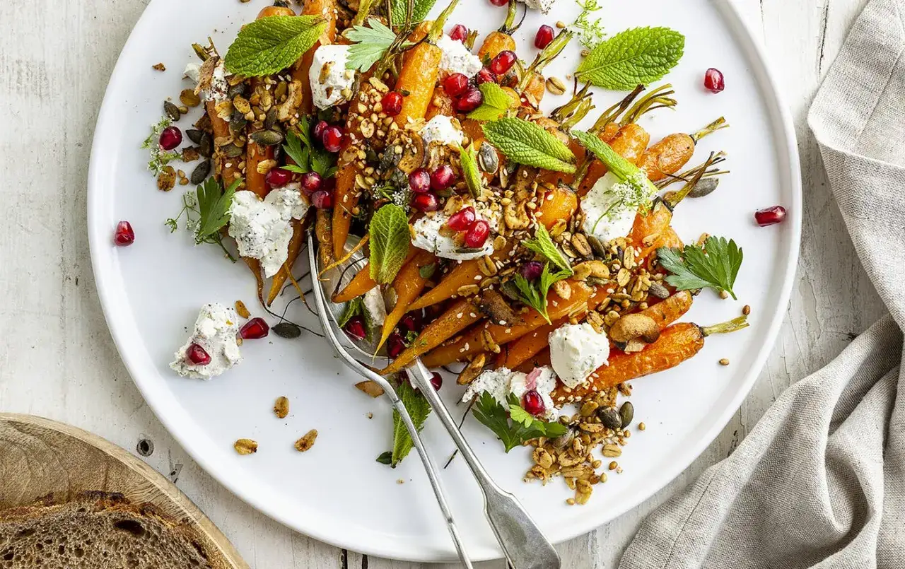 Carottes r&ocirc;ties garnies de fromage frais, grenade et granola croquant. Une recette carotte originale et color&eacute;e, parfaite pour un repas l&eacute;ger.