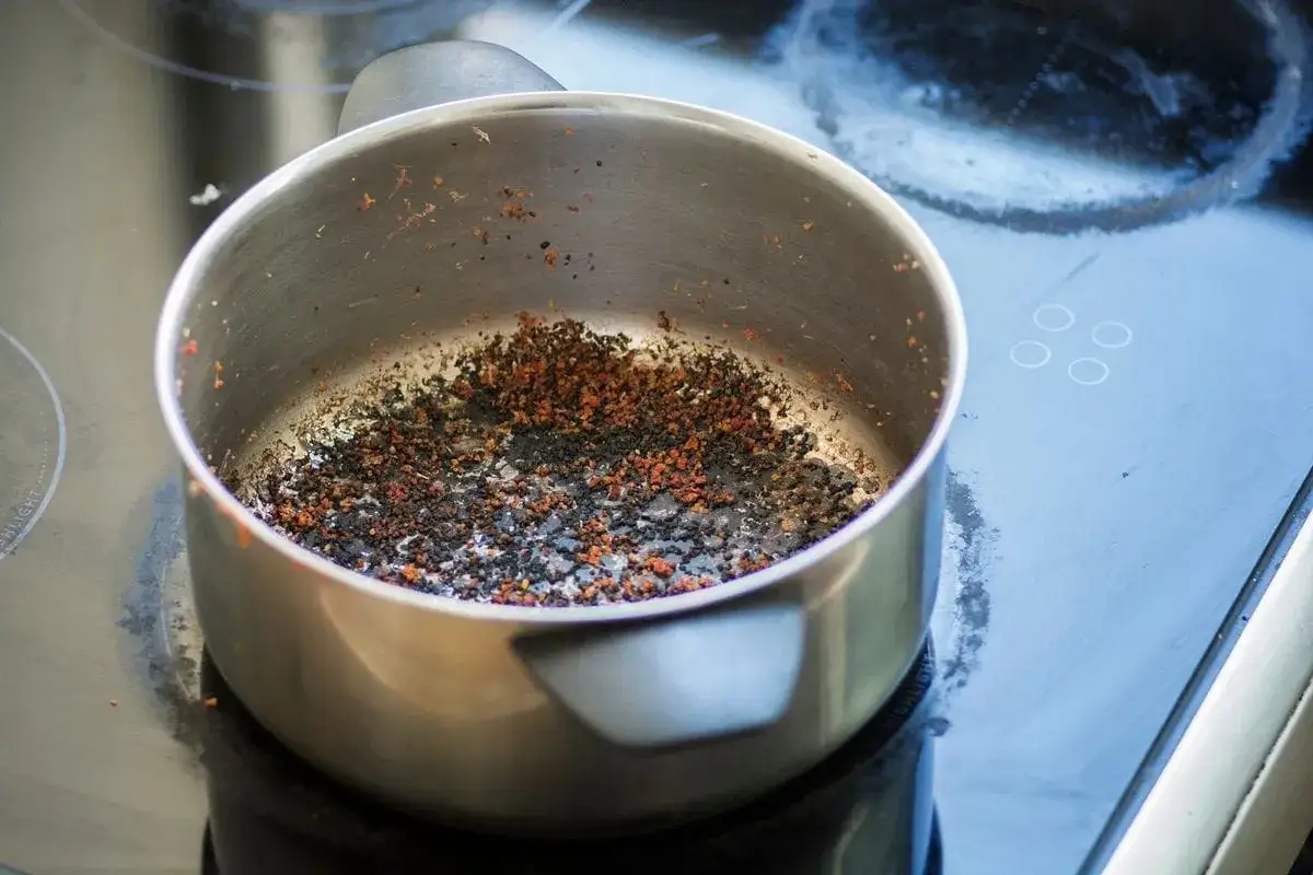 Casserole en inox br&ucirc;l&eacute;e, pleine de r&eacute;sidus carbonis&eacute;s. Une image qui pose la question : comment nettoyer une casserole br&ucirc;l&eacute;e en inox efficacement ?
