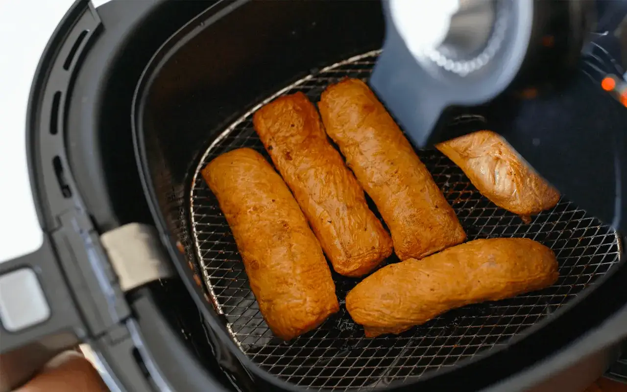 Cinq saucisses dor&eacute;es dans une friteuse sans huile. D&eacute;couvrez comment &ccedil;a marche pour des repas sains et croustillants !