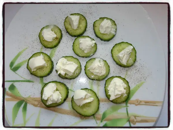 Apéro concombre st môret : rondelles de concombre garnies de fromage frais, saupoudrées de poivre. Parfait pour un apéritif léger et frais.