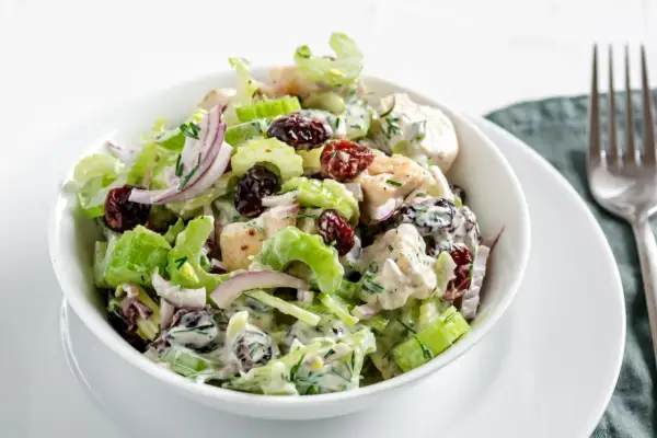 Salade de poulet crémeuse avec des morceaux de branche de céleri croquants, des canneberges séchées et des oignons rouges.