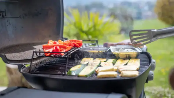 Poivrons rouges et courgettes grillés sur un barbecue à gaz. Le temps de cuisson barbecue gaz est idéal pour ces légumes savoureux.