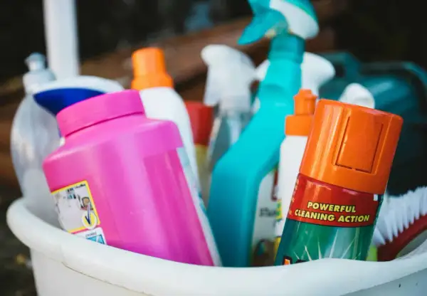 Un assortiment de produits de nettoyage, dont un spray bleu vif et une bouteille rose, prêts pour un nettoyage puissant. Ce produit fait maison est efficace.