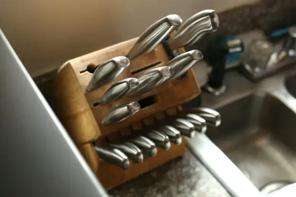 Un bloc en bois bien rangé pour une collection de couteaux de cuisine, montrant des lames en acier inoxydable prêtes à l'emploi.