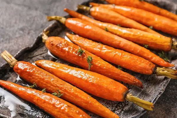 Carottes rôties glacées, garnies de thym frais. Une recette carotte originale qui met en valeur leur douceur naturelle.